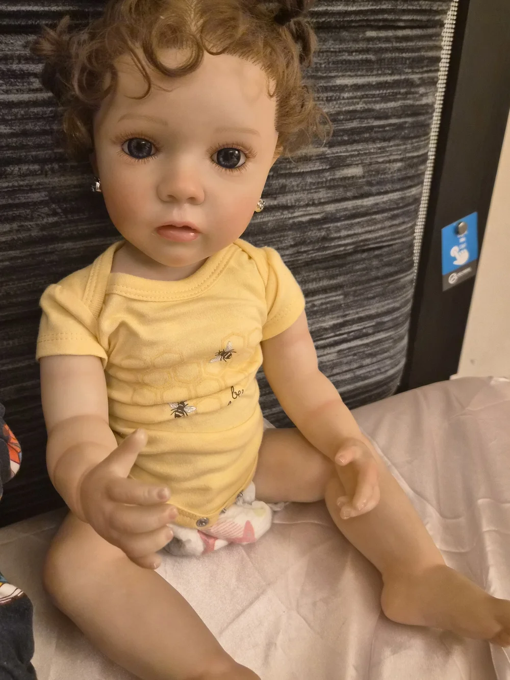 Reborn Baby Doll in Yellow Onesie with Curly Brown Hair